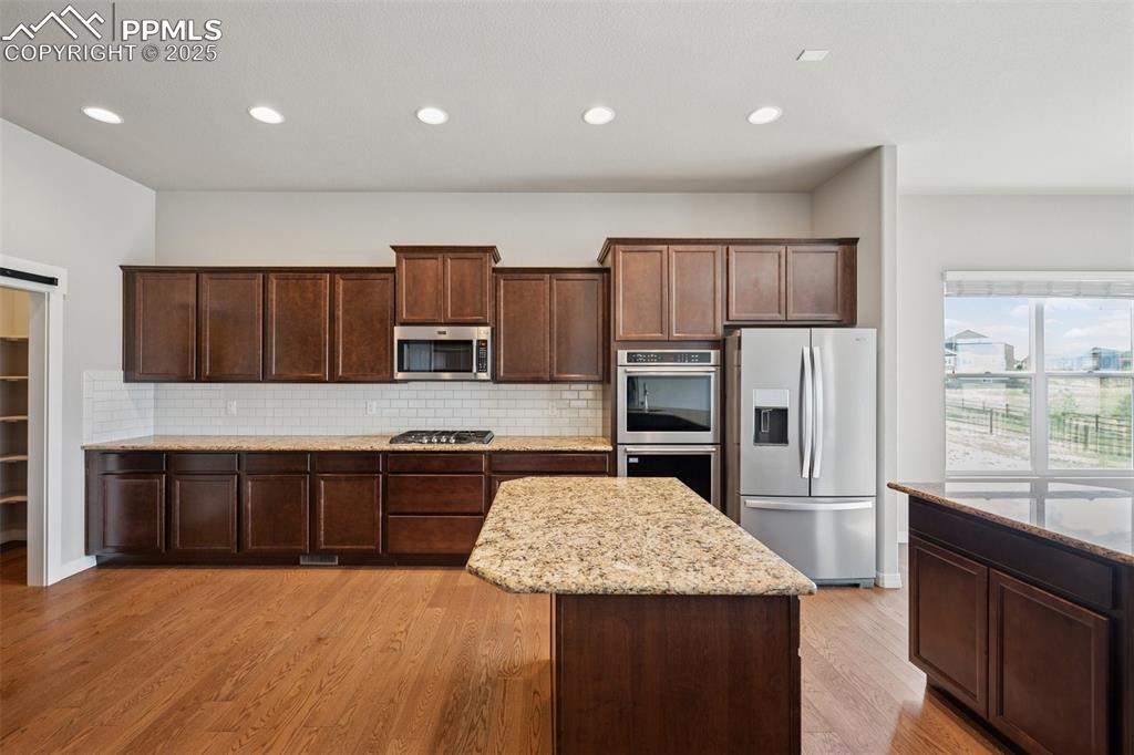 Image 4 of 38: Kitchen with appliances with stainless steel finishes, decorative backsplas