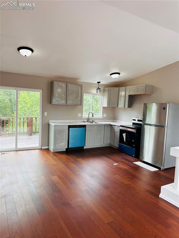 Image 3 of 11: Kitchen featuring freestanding refrigerator, light countertops, black elect
