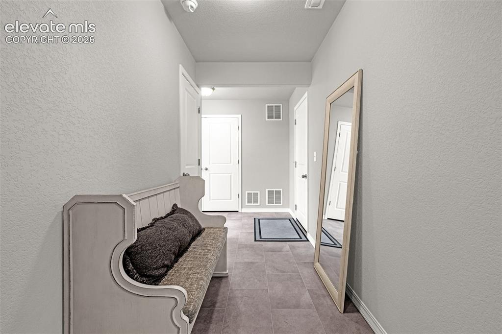 Image 17 of 46: Entryway featuring tiled flooring, light gray walls, white baseboards, and 