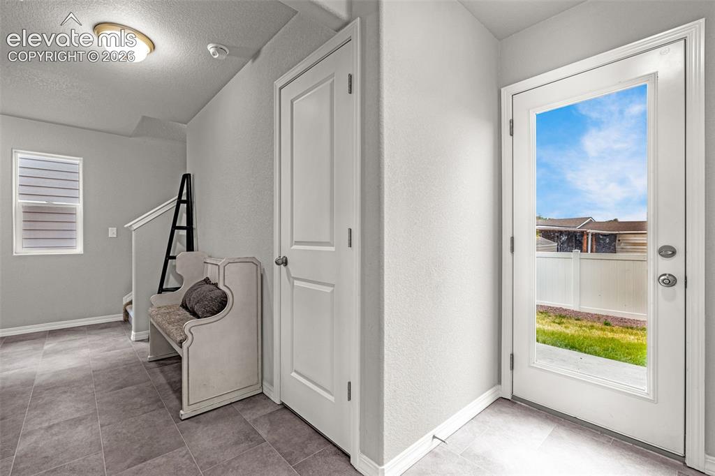 Image 18 of 46: Entryway featuring a full-light exterior door, grey tile flooring, neutral 