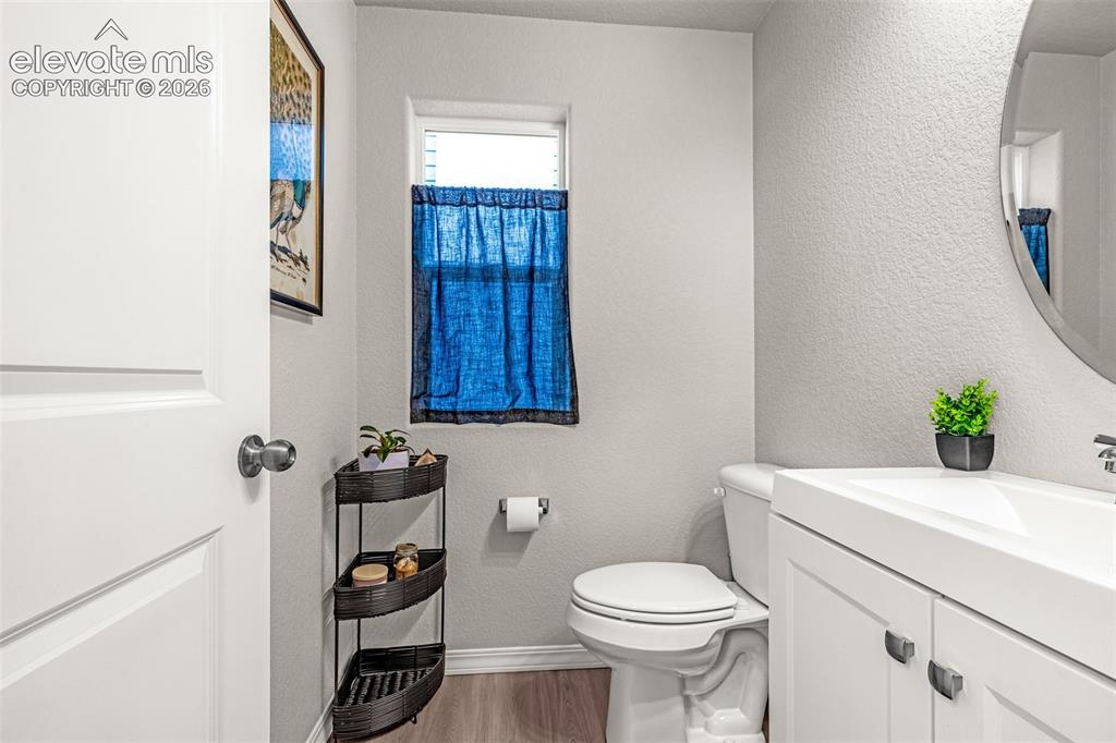 Image 19 of 46: Bathroom featuring a white vanity with integrated sink, a large oval mirror