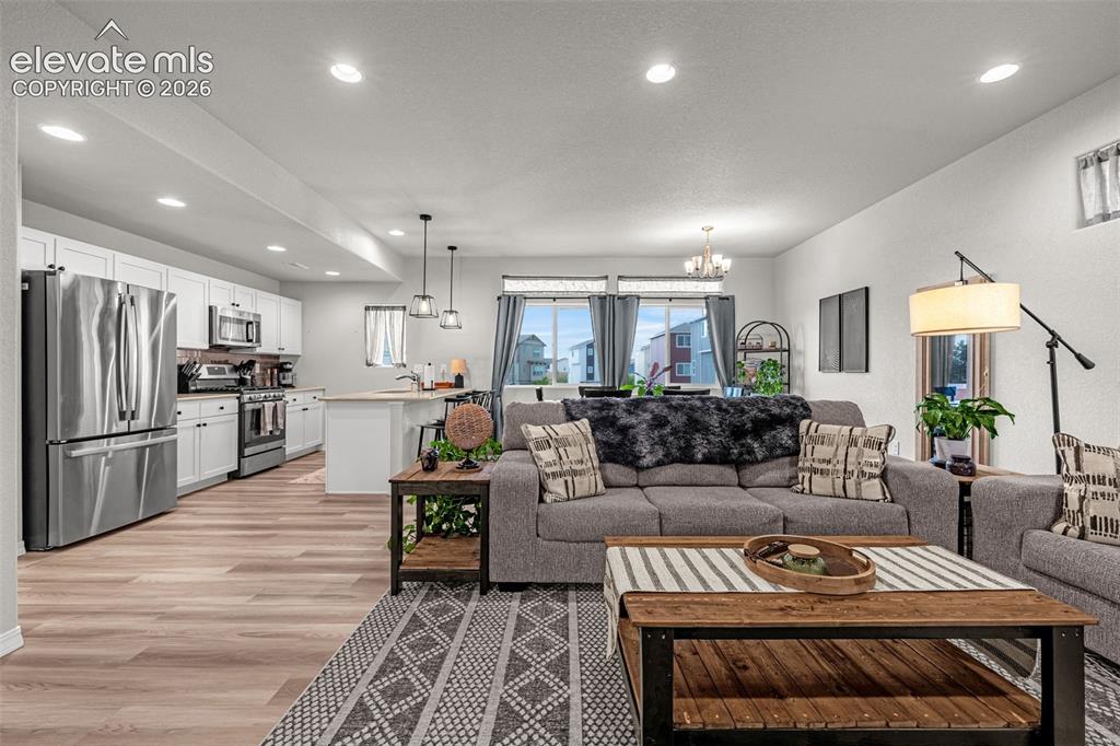 Image 2 of 46: Open-concept living space featuring wood-finish flooring throughout, recess