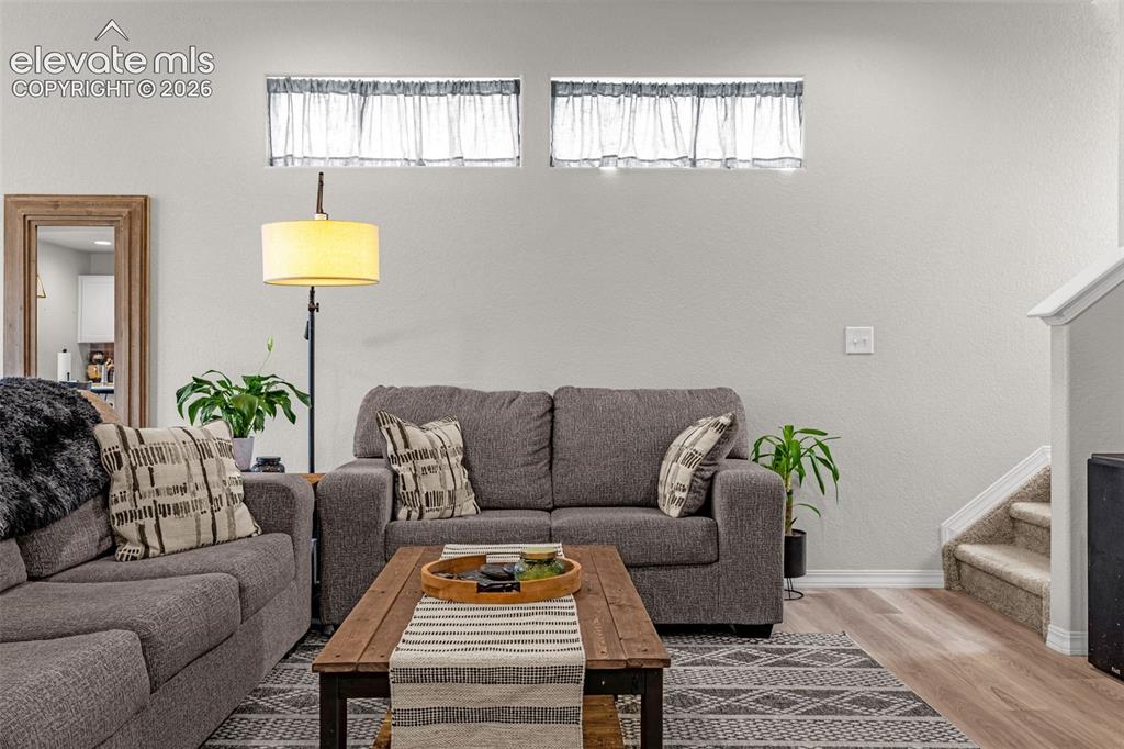 Image 21 of 46: Living area featuring two high transom windows with sheer curtain panels