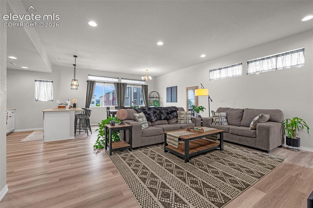 Image 22 of 46: Open-concept living area featuring wood-finish flooring, recessed lighting,
