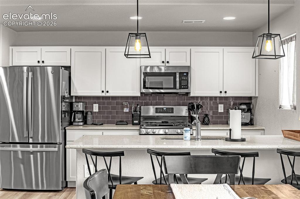 Image 25 of 46: Contemporary kitchen featuring stainless steel appliances, white shaker cab