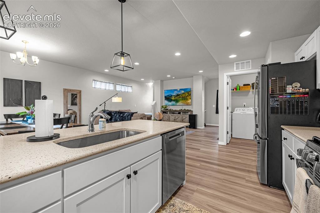 Image 29 of 46: Kitchen island featuring an undermount sink, gooseneck faucet, light-toned 