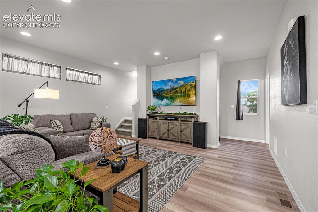 Image 31 of 46: Open-concept living area featuring wood-finish flooring, recessed lighting,