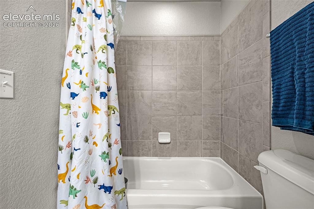 Image 36 of 46: Bathtub with light gray tile surround