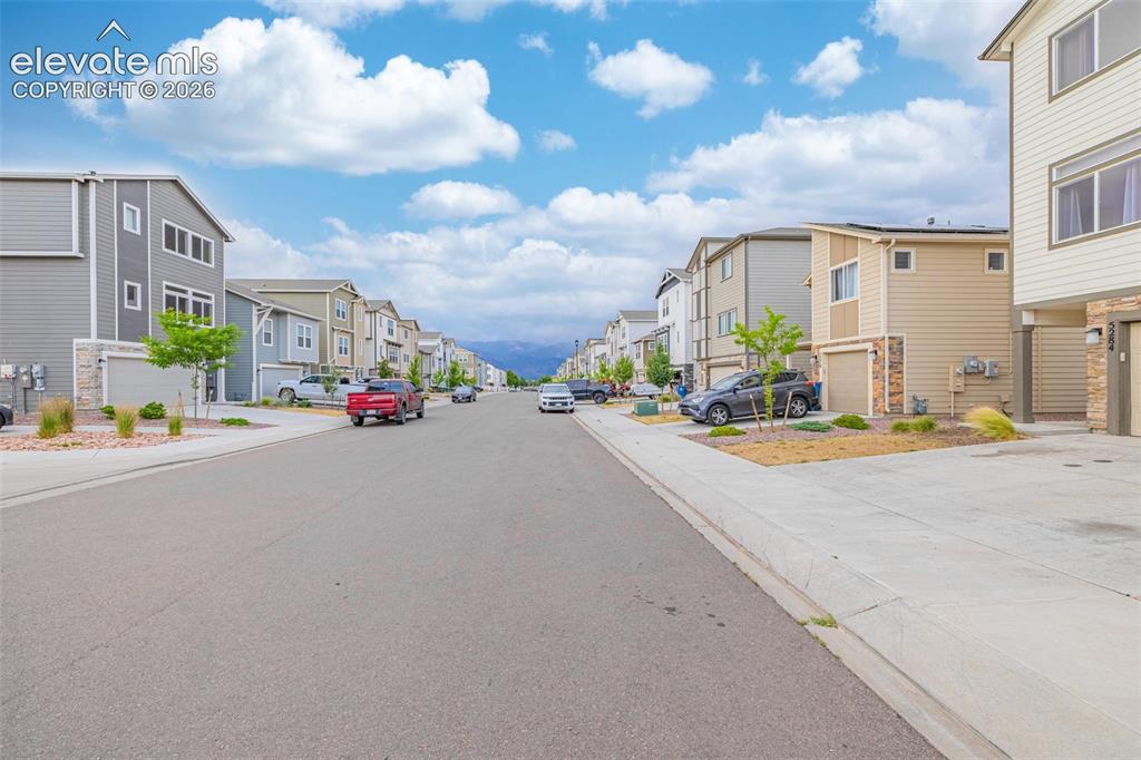 Image 46 of 46: Residential street featuring multi-level homes with varied exterior siding 