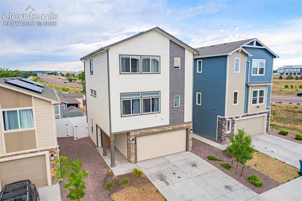 Image 7 of 46: Contemporary three-story home featuring a combination of horizontal siding 