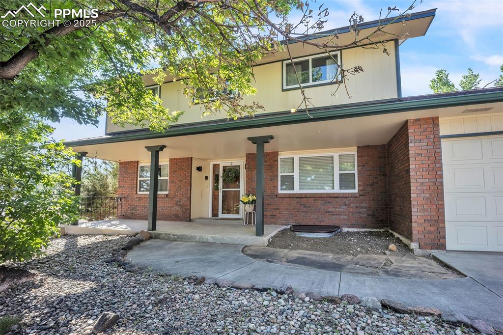 Image 2 of 49: Traditional-style home featuring a porch, brick siding, and an attached gar