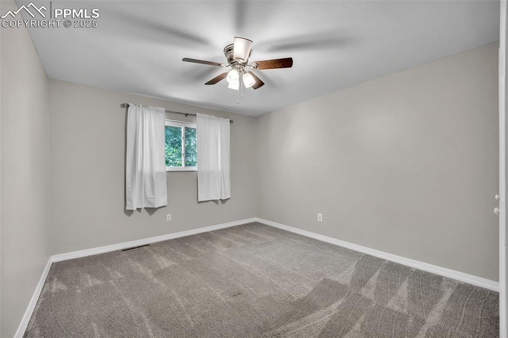Image 20 of 49: Carpeted empty room with baseboards and a ceiling fan