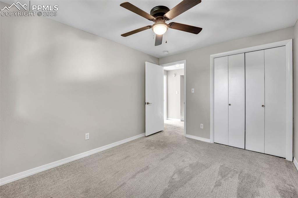 Image 23 of 49: Unfurnished bedroom featuring carpet flooring, a ceiling fan, and a closet