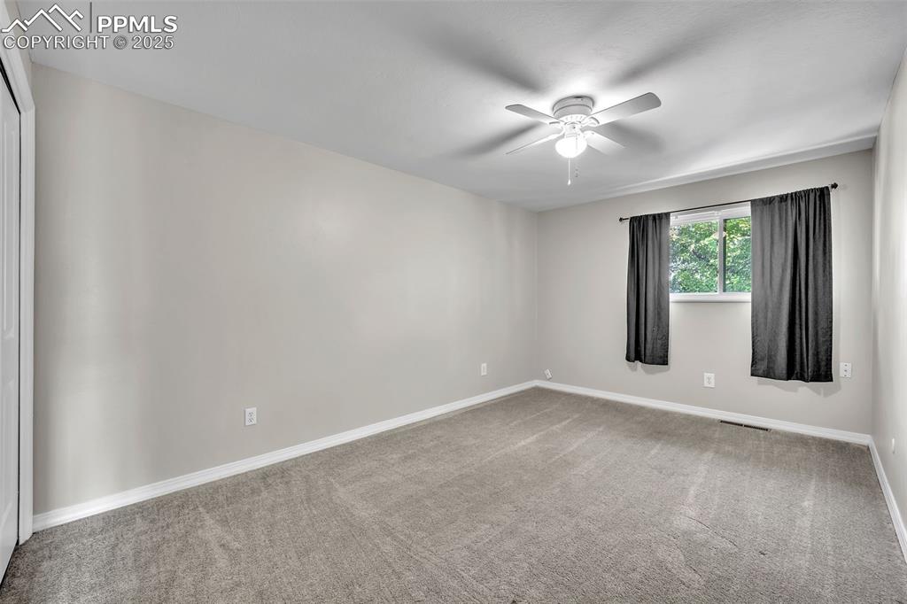 Image 24 of 49: Spare room featuring light colored carpet and a ceiling fan