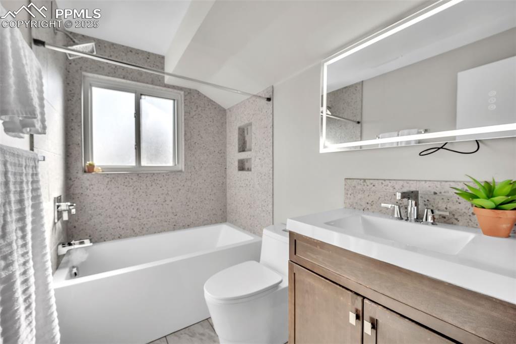 Image 26 of 49: Bathroom with shower / bath combo with shower curtain, vanity, and lofted c