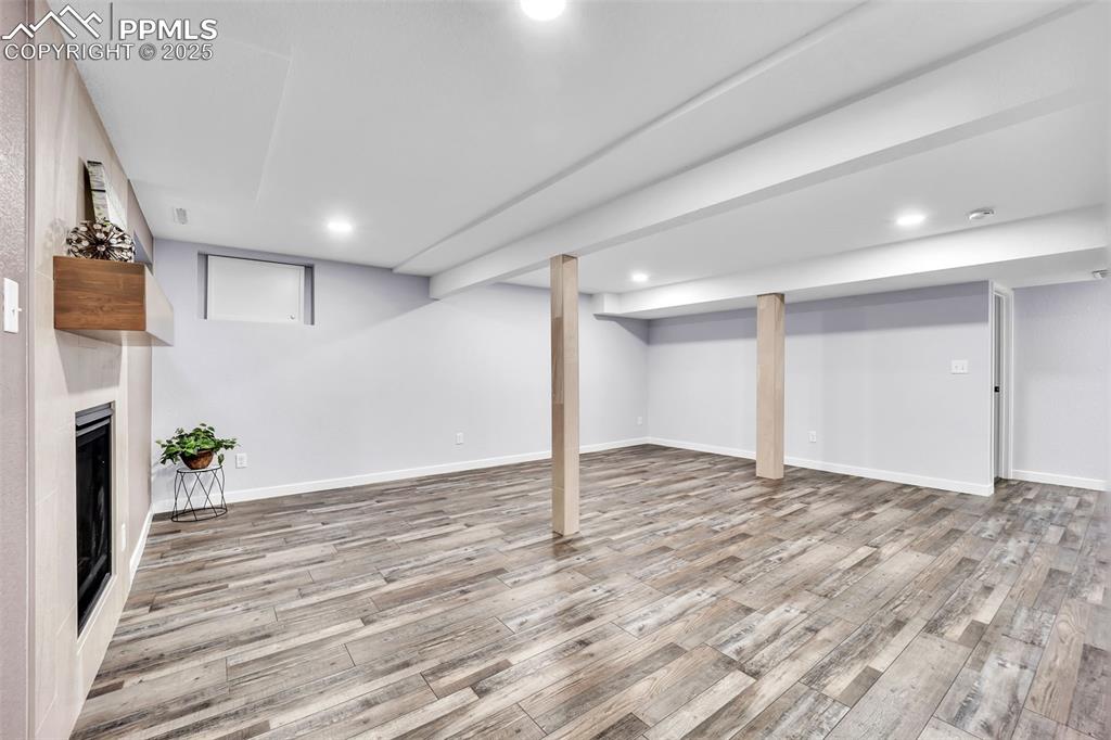 Image 29 of 49: Finished below grade area featuring recessed lighting, a fireplace, and lig