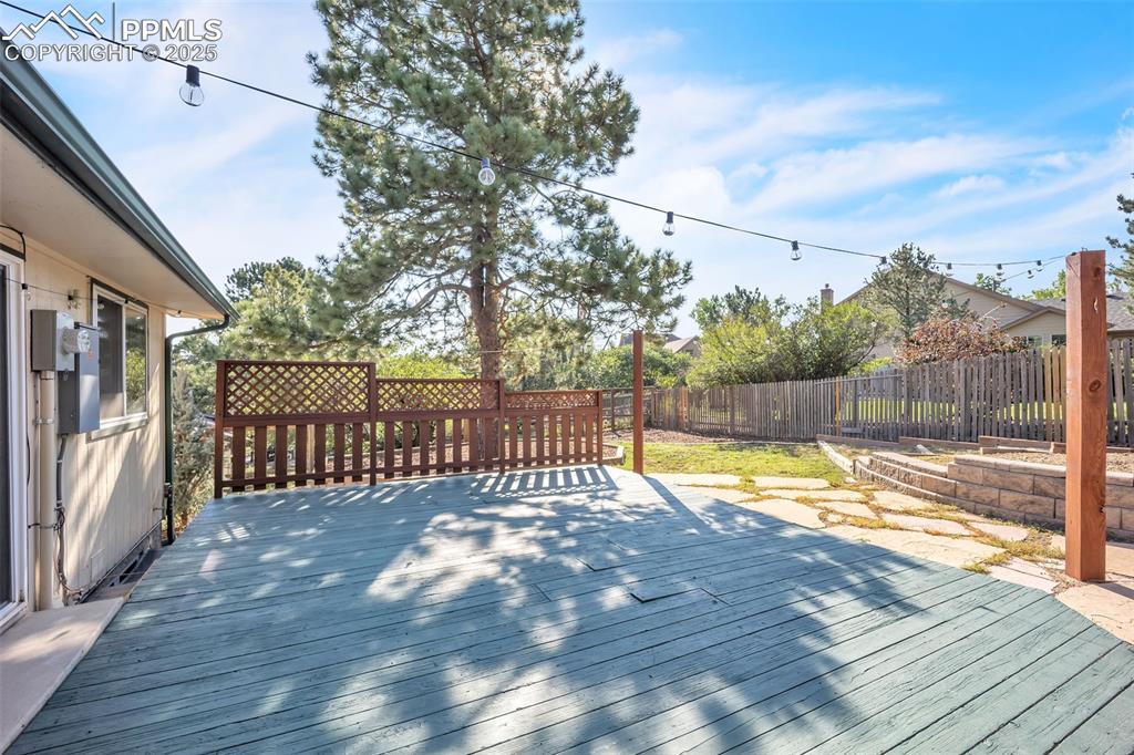Image 40 of 49: Wooden terrace with a fenced backyard and a garden