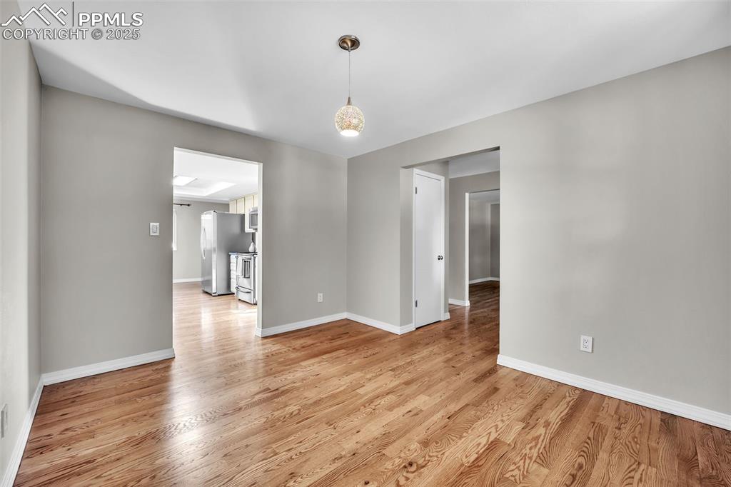 Image 6 of 49: Unfurnished room with light wood-type flooring and baseboards