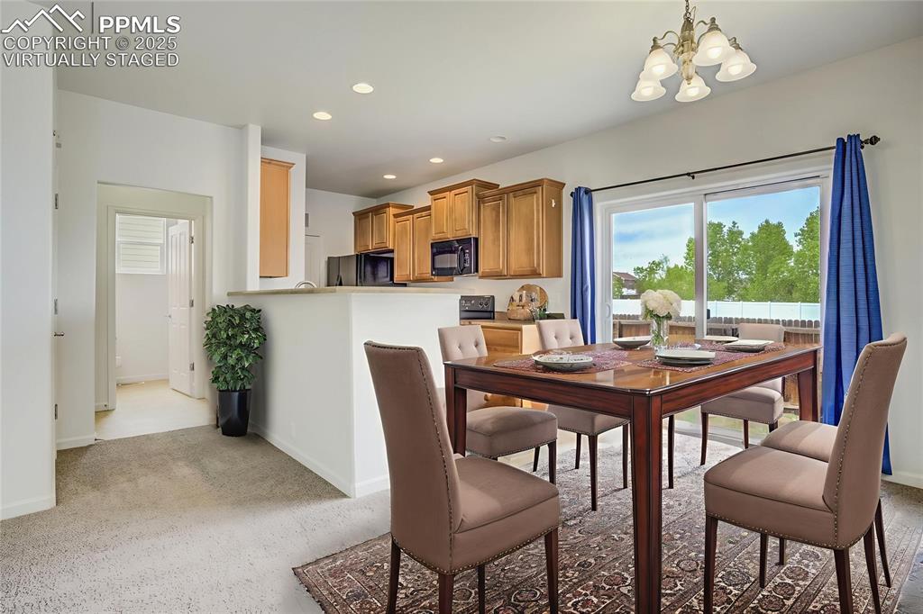 Image 14 of 50: Virtually staged dining area with walk out and half bath off kitchen