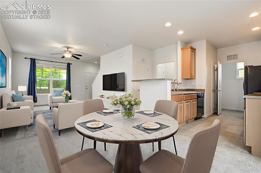 Image 19 of 50: Virtually staged dining area and living room off kitchen and laundry area