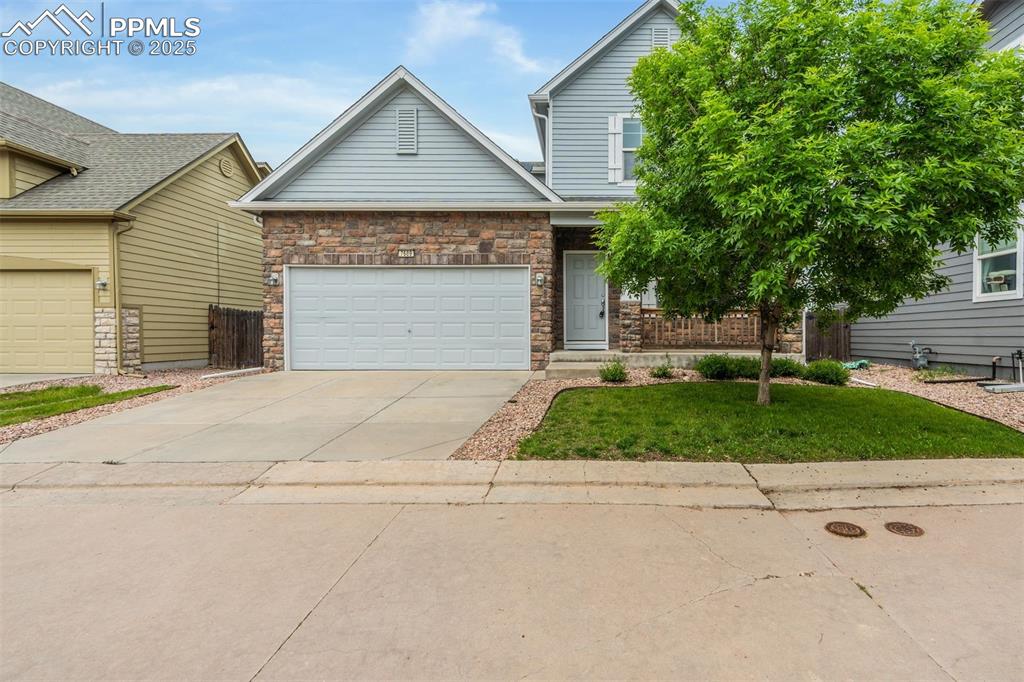 Image 2 of 50: View of front facade featuring concrete driveway, a front yard, a garage, a