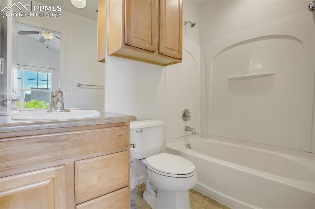 Image 32 of 50: Primary bathroom featuring vanity, toilet, a ceiling fan, washtub / shower 