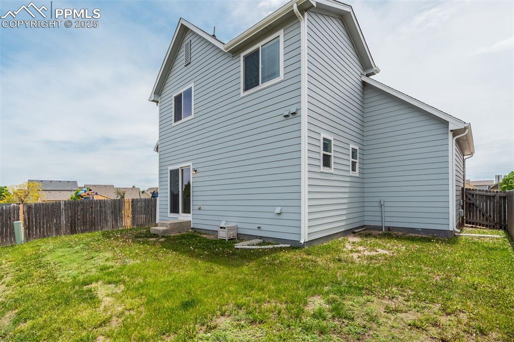 Image 47 of 50: View of back of house and fenced yard