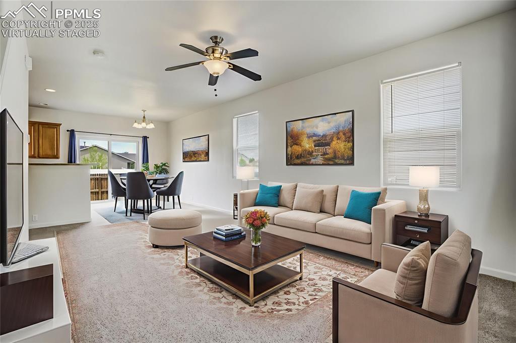 Image 6 of 50: Virtually staged living room and dining area from entry