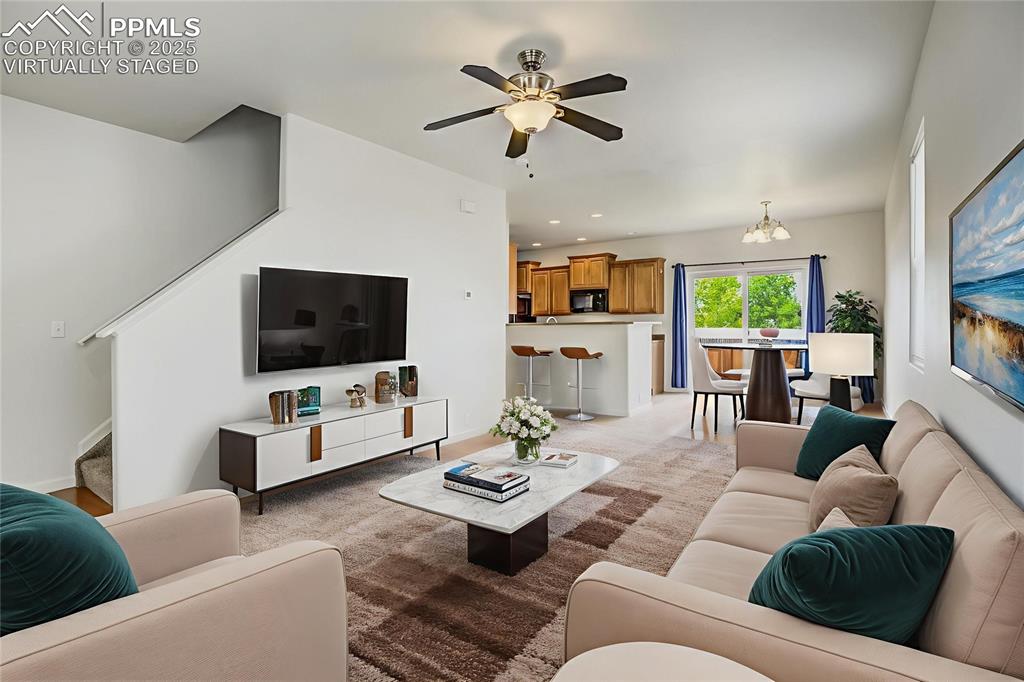 Image 8 of 50: Virtually staged living room and dining area toward stairs