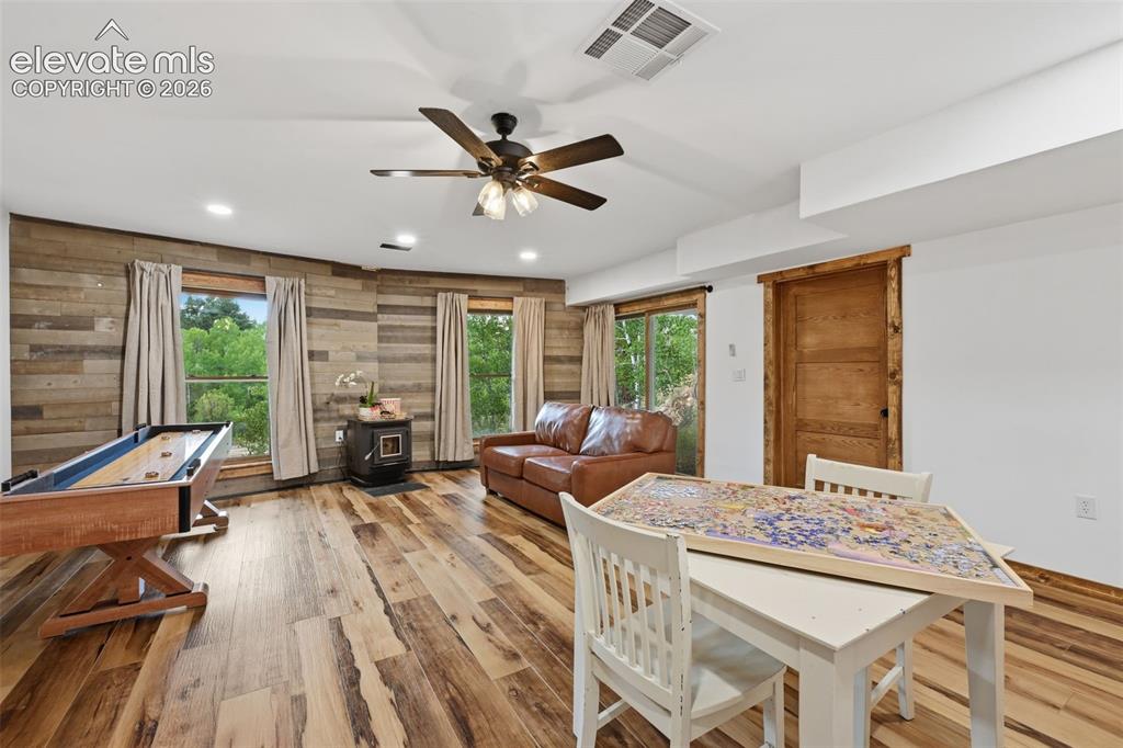 Image 24 of 33: Basement family room with pellet stove