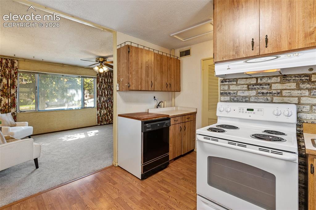 Image 17 of 45: Kitchen featuring wood-finish flooring, wood cabinetry, white countertops,