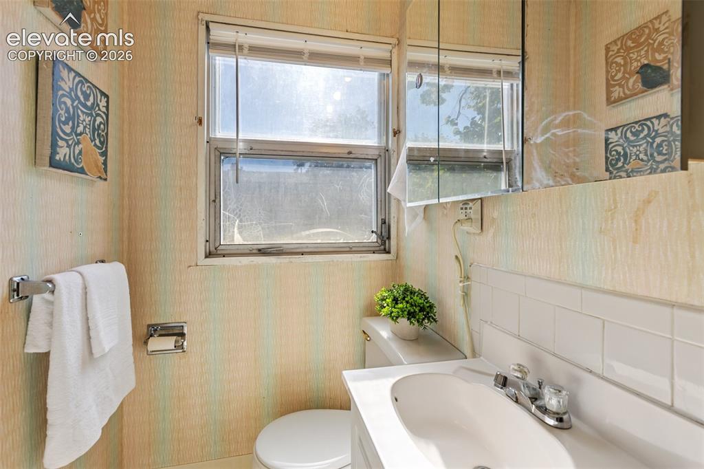 Image 23 of 45: White ceramic sink with chrome faucet, white countertop, and white subway t