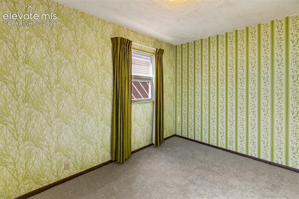 Image 25 of 45: Textured wallpaper with distinct patterns and a window with blinds