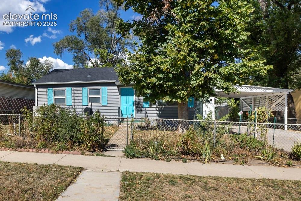 Image 3 of 45: Gray siding exterior with a dark shingle roof, accented by vibrant blue win
