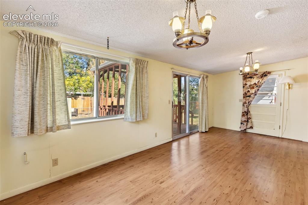 Image 33 of 45: Wood-finish flooring throughout, with two distinct chandelier fixtures