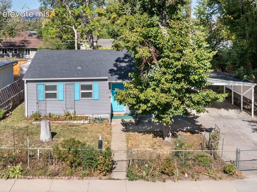 Image 4 of 45: Gray horizontal siding, light blue shutters, carport with lattice detailing
