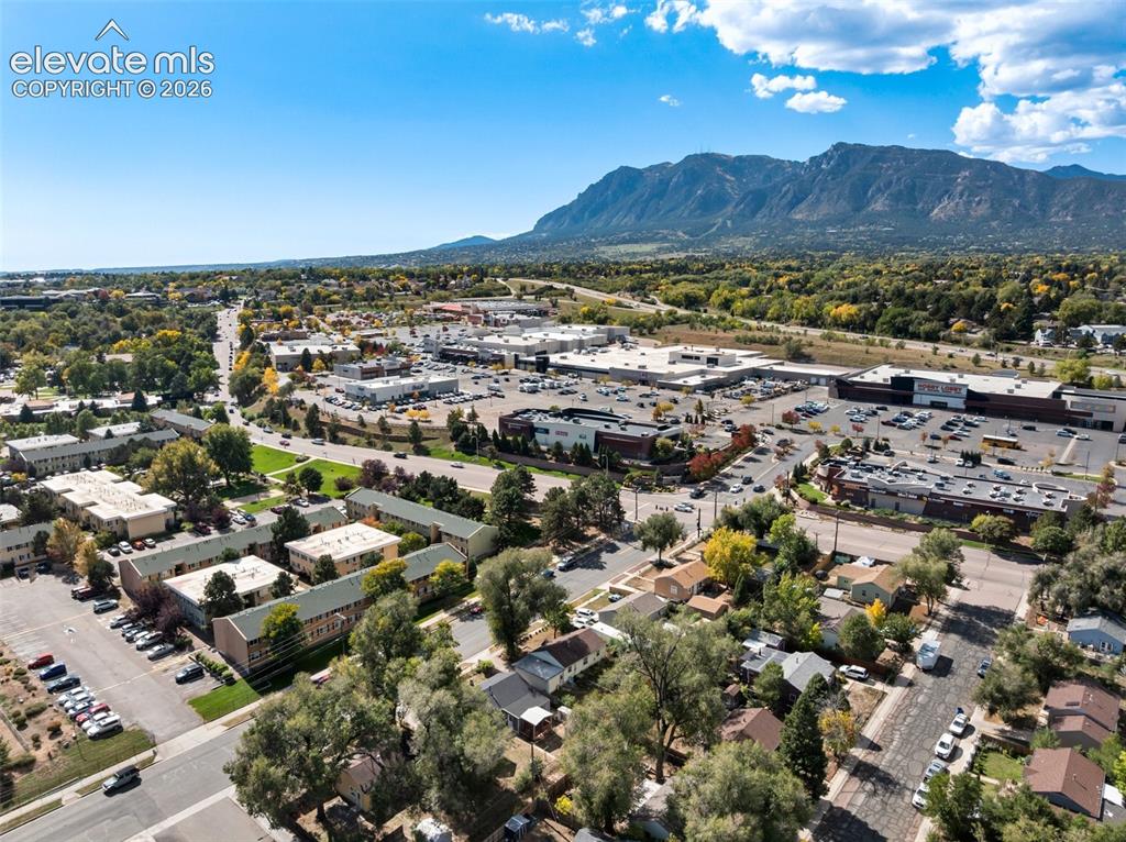 Image 44 of 45: Expansive urban landscape with mountainous backdrop, featuring commercial r