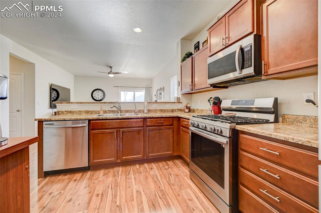 Image 12 of 45: Kitchen featuring appliances with stainless steel finishes, sink, a texture