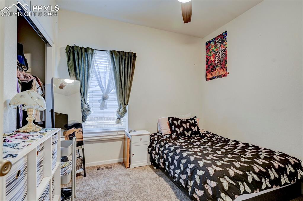 Image 20 of 45: Bedroom featuring light carpet, multiple windows, and ceiling fan