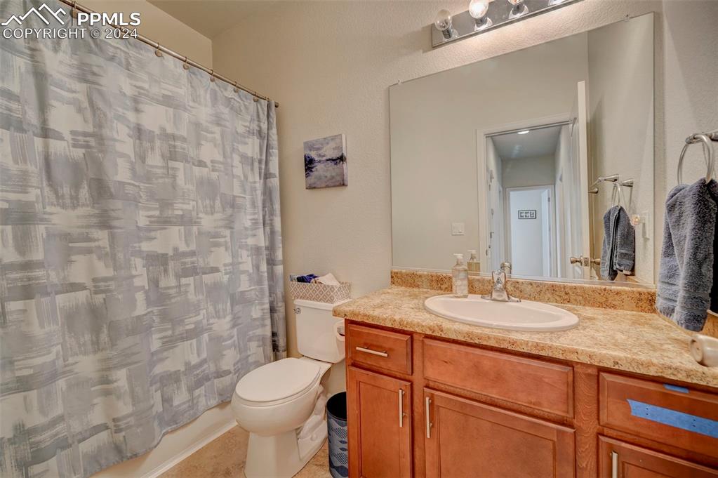 Image 23 of 45: Full bathroom with vanity, toilet, shower / bath combo with shower curtain,
