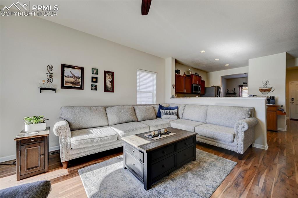 Image 6 of 45: Living room featuring wood-type flooring and ceiling fan