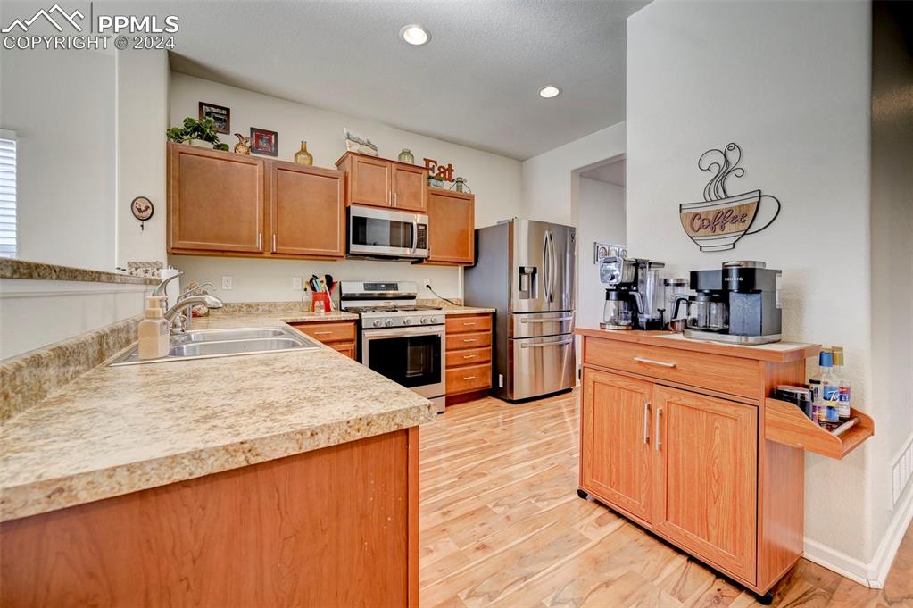 Image 9 of 45: Kitchen featuring appliances with stainless steel finishes, sink, and light