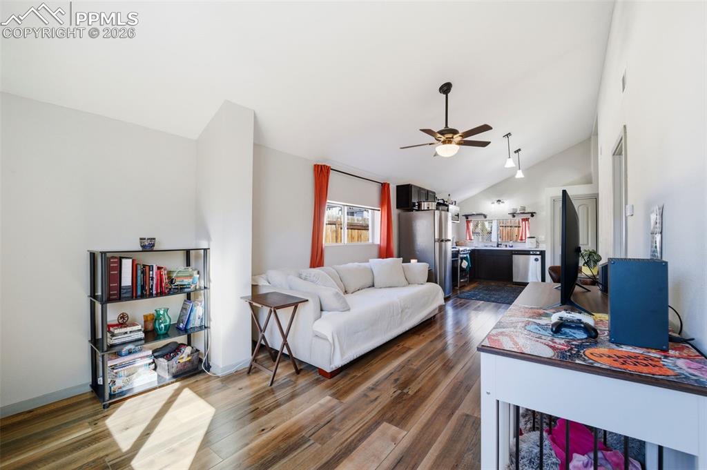 Image 17 of 35: Living room featuring lofted ceiling, LVP floors, and a ceiling fan