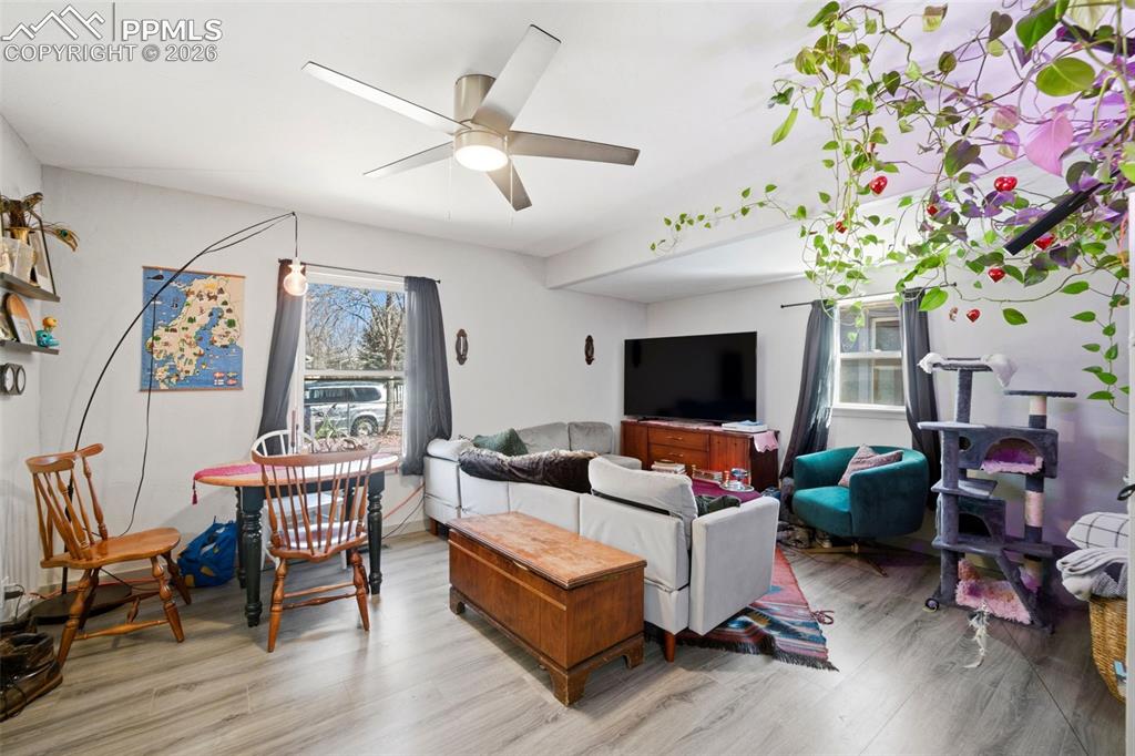 Image 2 of 35: Living area with newer LVP floors and ceiling fan