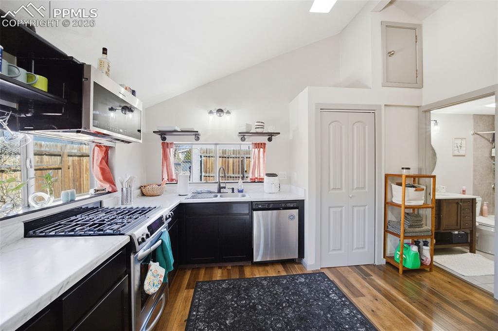 Image 21 of 35: Kitchen featuring stainless steel appliances and vaulted ceilings