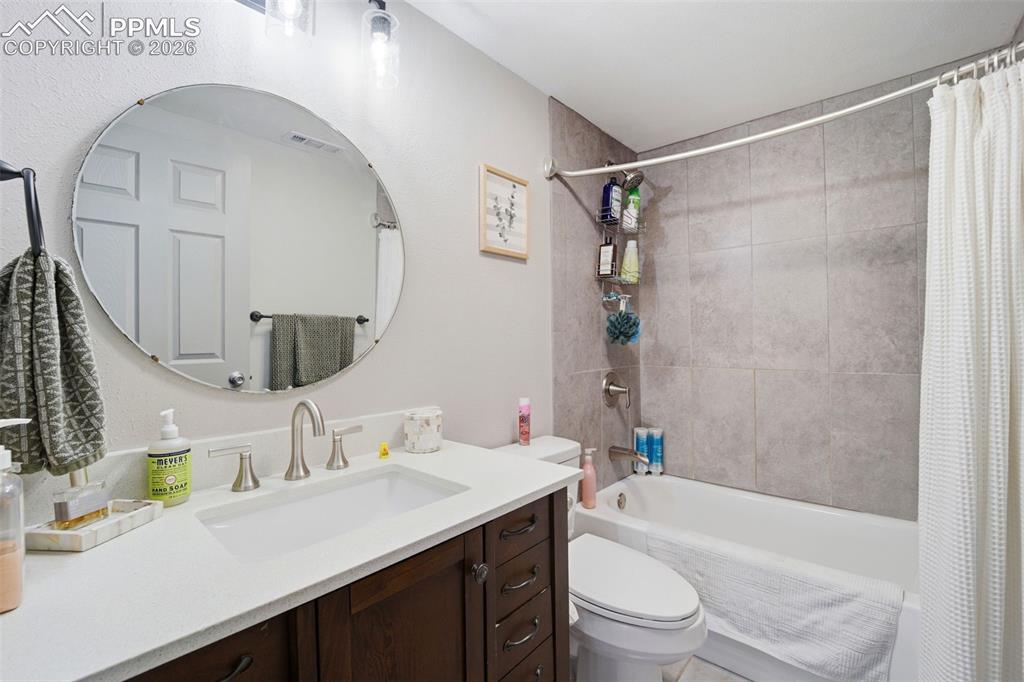 Image 24 of 35: Full bathroom with vanity and shower / bathtub combination with curtain