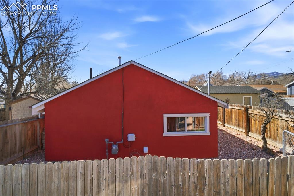 Image 32 of 35: View of back of cottage with a fenced backyard