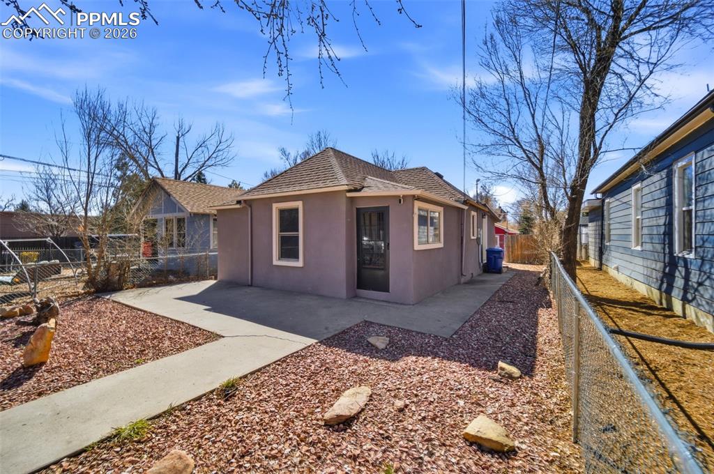 Image 34 of 35: View of back of cottage with a fenced backyard