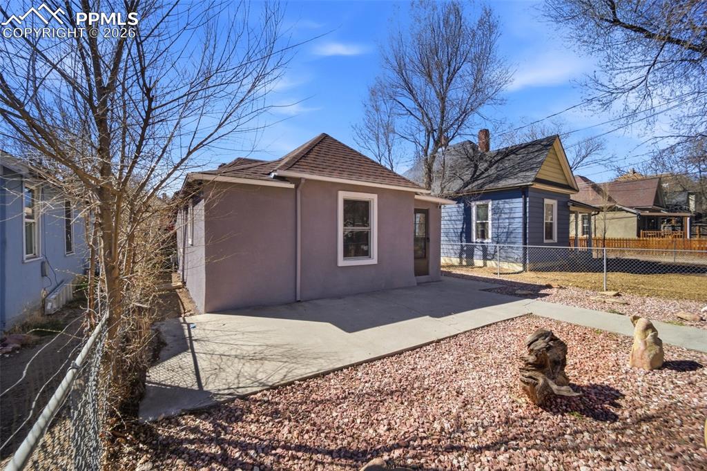 Image 35 of 35: View of front of house with stucco siding, a fenced front yard, and a gate
