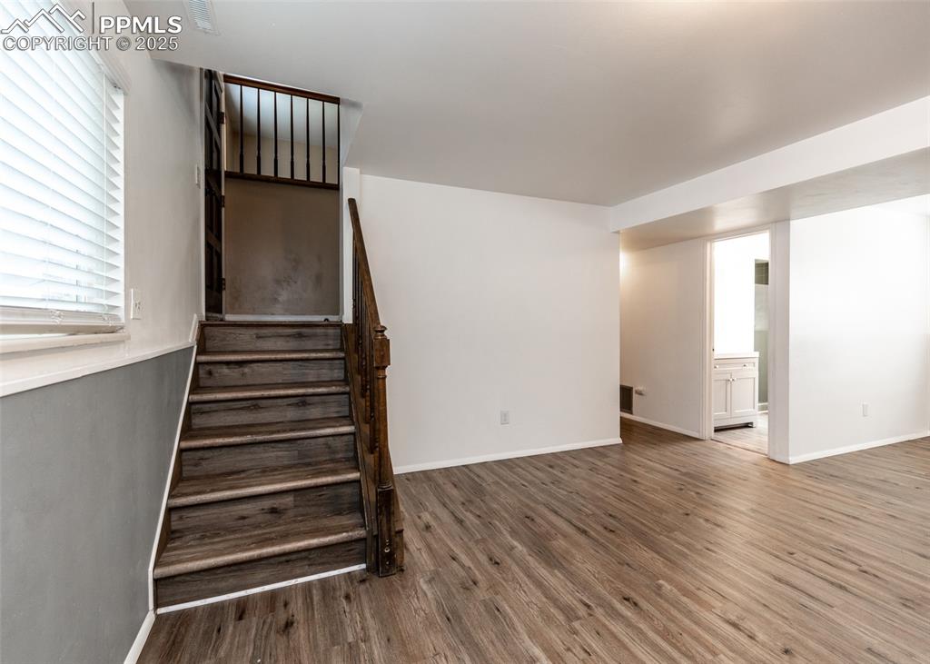 Image 13 of 22: Staircase featuring wood finished floors and baseboards